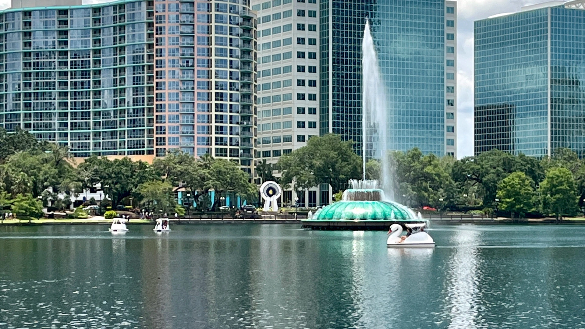 Lake Eola fountain and the downtown Orlando skyline, with swan boats on the water